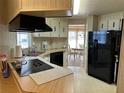 Functional kitchen layout with black appliances, light wood cabinets, and access to the dining area at 22 Nautical Dr, North Port, FL 34287
