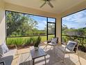 Relaxing screened porch with seating, a ceiling fan, and views of lush backyard landscaping at 220 Sarezzo Cir, Nokomis, FL 34275