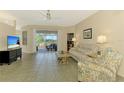 Bright living room features tile flooring, neutral walls and a sliding glass door to patio at 2318 Harrier Way, Nokomis, FL 34275