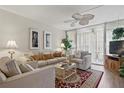 Inviting living room with comfortable seating, ceiling fan, and access to a private balcony at 244 Saint Augustine # 605, Venice, FL 34285