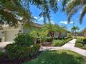 Charming home featuring an attached two-car garage and colorful landscaping at 275 Capulet Dr, Venice, FL 34292