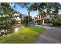 Beautiful home with a tile roof surrounded by mature trees and a pond at 2750 Gocio Road Ext, Sarasota, FL 34235