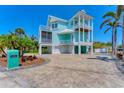 Coastal home with a three-story facade, white columns, balconies, and a paved driveway at 320 O Day, Englewood, FL 34223