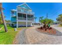 Side view of charming coastal style home featuring balconies and lush landscaping at 320 O Day, Englewood, FL 34223