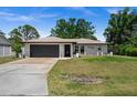 Single-story home featuring neutral paint, a dark gray garage door, and a concrete driveway at 3355 Roslyn Rd, Venice, FL 34293