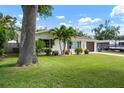 Beautiful single-story home with a lush lawn, mature trees, and well-maintained landscaping at 348 Dorchester Dr, Venice, FL 34293