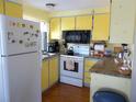 Efficient kitchen featuring bright yellow cabinets and essential appliances at 358 Longwood Dr, Venice, FL 34285
