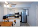 Bright kitchen with white cabinets, stainless steel appliances, and tile backsplash at 400 Base # 225, Venice, FL 34293