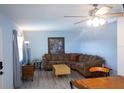 Cozy living room with a large sectional sofa, ceiling fan and neutral color palette at 400 Base # 225, Venice, FL 34293