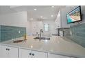 Contemporary kitchen design boasting white cabinets, sleek countertops, tile backsplash, and stainless steel appliances at 406 Cerromar N Cir # 128, Venice, FL 34293