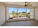 Enclosed lanai with tiled floor offers panoramic views of the manicured golf course and tropical landscaping at 406 Cerromar N Cir # 128, Venice, FL 34293
