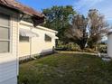 Residential home exterior view featuring a grassy backyard, white siding and awning accents at 411 Cervina N Dr # 493, Venice, FL 34285