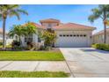 A charming home with a red tile roof, landscaped yard, and a two car garage at 4427 Blue Heron Cir, North Port, FL 34287