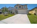 Charming two-story home featuring a well-manicured lawn and a spacious two car garage at 4523 Birdsong Dr, Palmetto, FL 34221