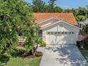 Well-maintained single-story home with terra cotta tile roof, manicured lawn, and an attached two-car garage at 4885 Tamarack Trl, Venice, FL 34293