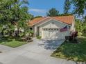 Traditional single-story home with terra cotta tile roof, attached two-car garage, and well-maintained lawn at 4885 Tamarack Trl, Venice, FL 34293