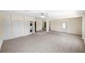 Spacious living area with light wood-look flooring, a laundry closet, and a decorative front door at 5992 Osprey Rd, Venice, FL 34293
