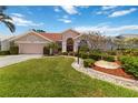 Inviting single Gathering home with lush front yard landscaping, rock features, and decorative lighting at 6507 Drewry'S Blf, Bradenton, FL 34203