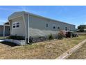 Exterior view of single-story home with low-maintenance yard and green siding at 6765 Laurel Ct, North Port, FL 34287