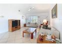 Cozy living room with neutral tile flooring, and comfortable seating, flooded with natural light from a large window at 985 Everest Rd, Venice, FL 34293