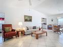 Open-concept living room showcasing tiled floors, comfortable furnishings, and seamless flow into the dining and kitchen areas at 985 Everest Rd, Venice, FL 34293