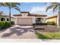 This lovely one story home features a brick driveway, two-car garage, covered porch and lush landscaping at 10093 Cozy Grove Dr, Venice, FL 34293