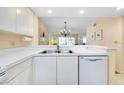 Bright kitchen featuring a stainless steel sink, dishwasher, and view to the adjacent dining and living room at 1018 Wexford Blvd # 1018, Venice, FL 34293