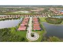 Aerial view of a residential community with tile-roofed homes nestled among lakes and green spaces at 10618 Corkwood Ct, Venice, FL 34293
