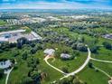 Drone's-eye view of the home on a sprawling green space that features pond, generous landscaping, and lengthy winding driveway at 1104 Twin Laurel Blvd, Nokomis, FL 34275