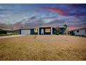 Beautiful single-story home featuring a well-manicured lawn, complemented by a serene evening sky at 144 Rotonda Cir, Rotonda West, FL 33947