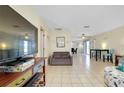 Spacious living room featuring neutral tile floors, a comfortable couch, and a ceiling fan at 144 Rotonda Cir, Rotonda West, FL 33947