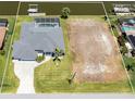 An aerial view of the property, including the home, pool, dock, waterfront, and an adjacent vacant lot at 15448 Avery Rd, Port Charlotte, FL 33981