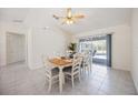 Bright dining area with tile floors, white furniture, and sliding glass doors to the pool area at 1568 Ringtail Rd, Venice, FL 34293