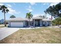 Charming single-story home with a white tile roof, well-maintained lawn and swaying palm trees at 1568 Ringtail Rd, Venice, FL 34293