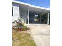 Home boasts a spacious carport with ample parking and a beautifully landscaped entryway at 177 Palm Harbor Dr, North Port, FL 34287