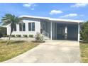 Inviting home featuring a covered carport, well-maintained lawn, and charming front entryway at 177 Palm Harbor Dr, North Port, FL 34287