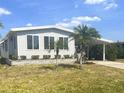 Single-story home boasts mature landscaping, vibrant green grass, and a covered carport at 177 Palm Harbor Dr, North Port, FL 34287