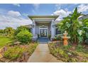 Grand front entrance features double doors, lovely landscaping, and an inviting walkway at 2000 Jasmine Way, North Port, FL 34287
