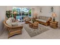 Comfortable living room with wicker furniture and a view of the pool through sliding glass doors at 2022 Calusa Lakes Blvd, Nokomis, FL 34275