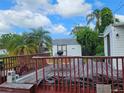 Wooden back deck with outdoor seating and lush tropical surroundings at 205 Jessica N St, Nokomis, FL 34275