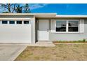 A well maintained single-story home featuring a garage and a neatly kept lawn at 2980 Siesta Dr, Venice, FL 34293