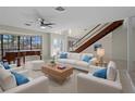 Inviting living room with ample seating, piano, and staircase; perfect for entertaining and comfortable living at 318 Oakwood Cir, Englewood, FL 34223