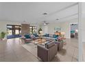 Spacious living room featuring tile floors, neutral furniture with blue accents, and a view of the screened patio at 318 Oakwood Cir, Englewood, FL 34223
