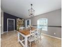 Dining area with a rustic table and chairs, a stylish pendant light, and neutral wall colors at 3255 Tally Ho Rd # 1, North Port, FL 34291