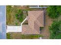 Aerial view of a cozy, single-Gathering home with a brown roof, driveway, and surrounding greenery at 3870 Log Cabin Rd, North Port, FL 34291