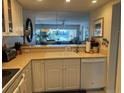 Bright kitchen with white cabinetry, modern appliances, and a view to the dining and living area at 406 Laurel Lake Dr # 103, Venice, FL 34292