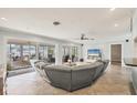 Open-concept living room featuring neutral tile floors, modern ceiling fan, and sliding glass doors to lanai at 421 Blackburn Rd, Nokomis, FL 34275