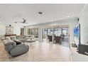 Spacious living room with neutral tile, modern fan, and sliding glass doors that enhance natural light and views at 421 Blackburn Rd, Nokomis, FL 34275