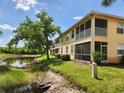 Exterior view of a condo with a screened-in patio overlooking a tranquil pond and lush greenery at 4213 Vicenza Dr # A2, Venice, FL 34293