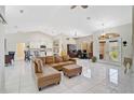 Bright living area featuring tile floors, a comfortable leather sectional sofa, and views of adjacent rooms at 4856 Jacaranda Heights Dr, Venice, FL 34293